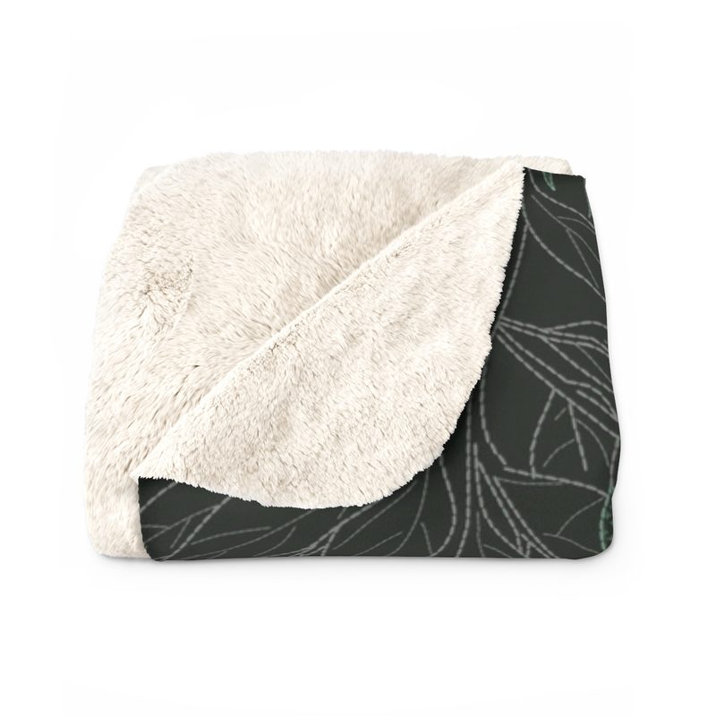 Jungle blanket folded, with one corner turned back to show the plain ivory sherpa fleece reverse