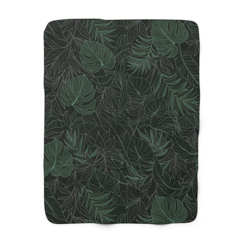 Jungle sherpa fleece blanket laid flat: monstera, palm and broad-leaf outlines in jade green and pale grey on a near-black green ground